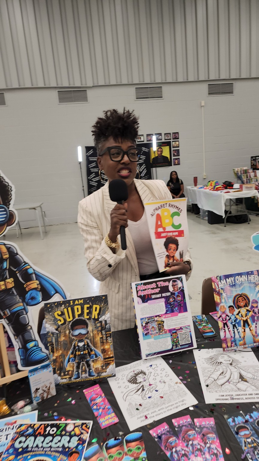 Tiffany speaking into a microphone while presenting one of her children's books