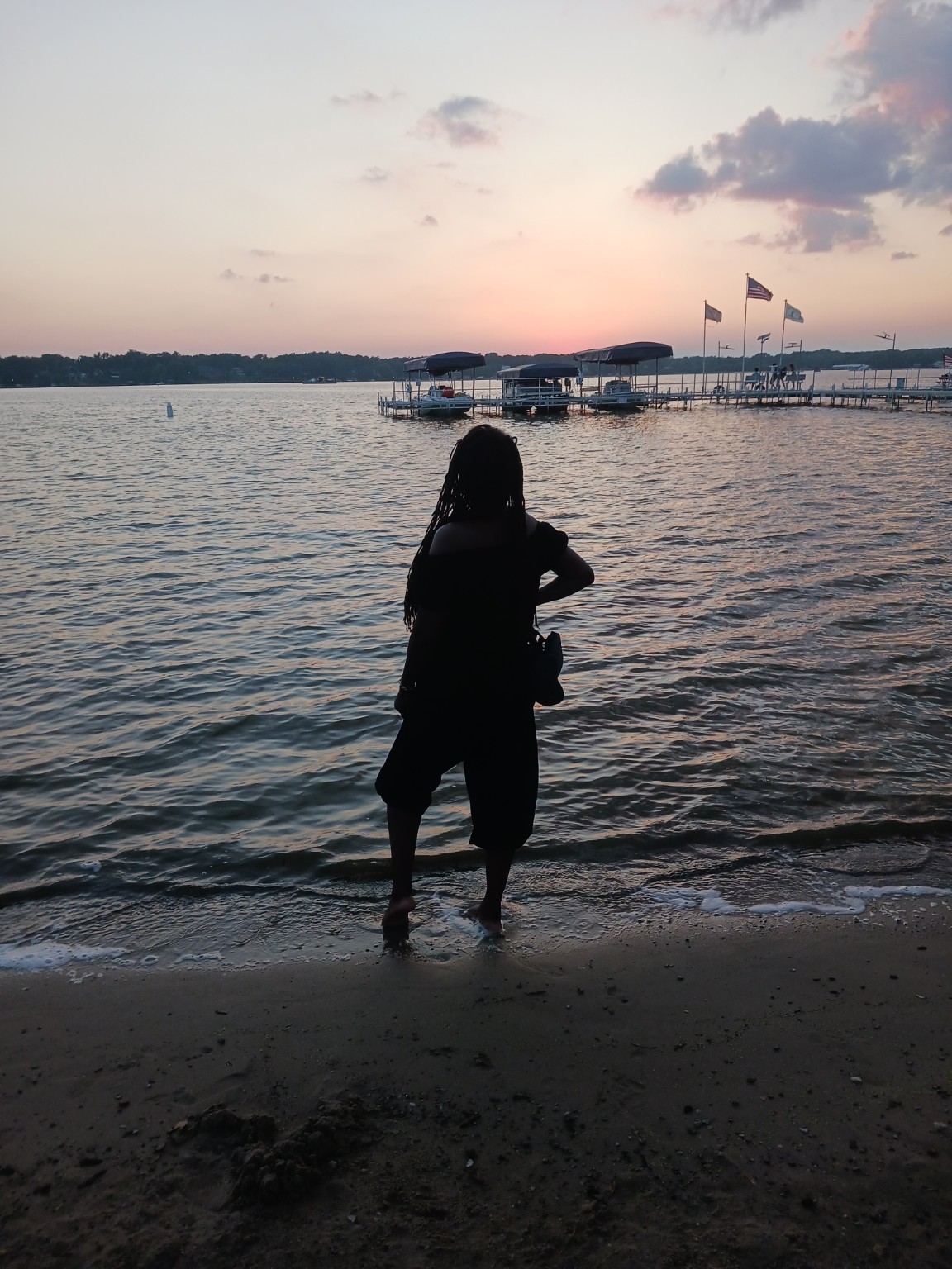 Tiffany standing at the water's edge during sunset