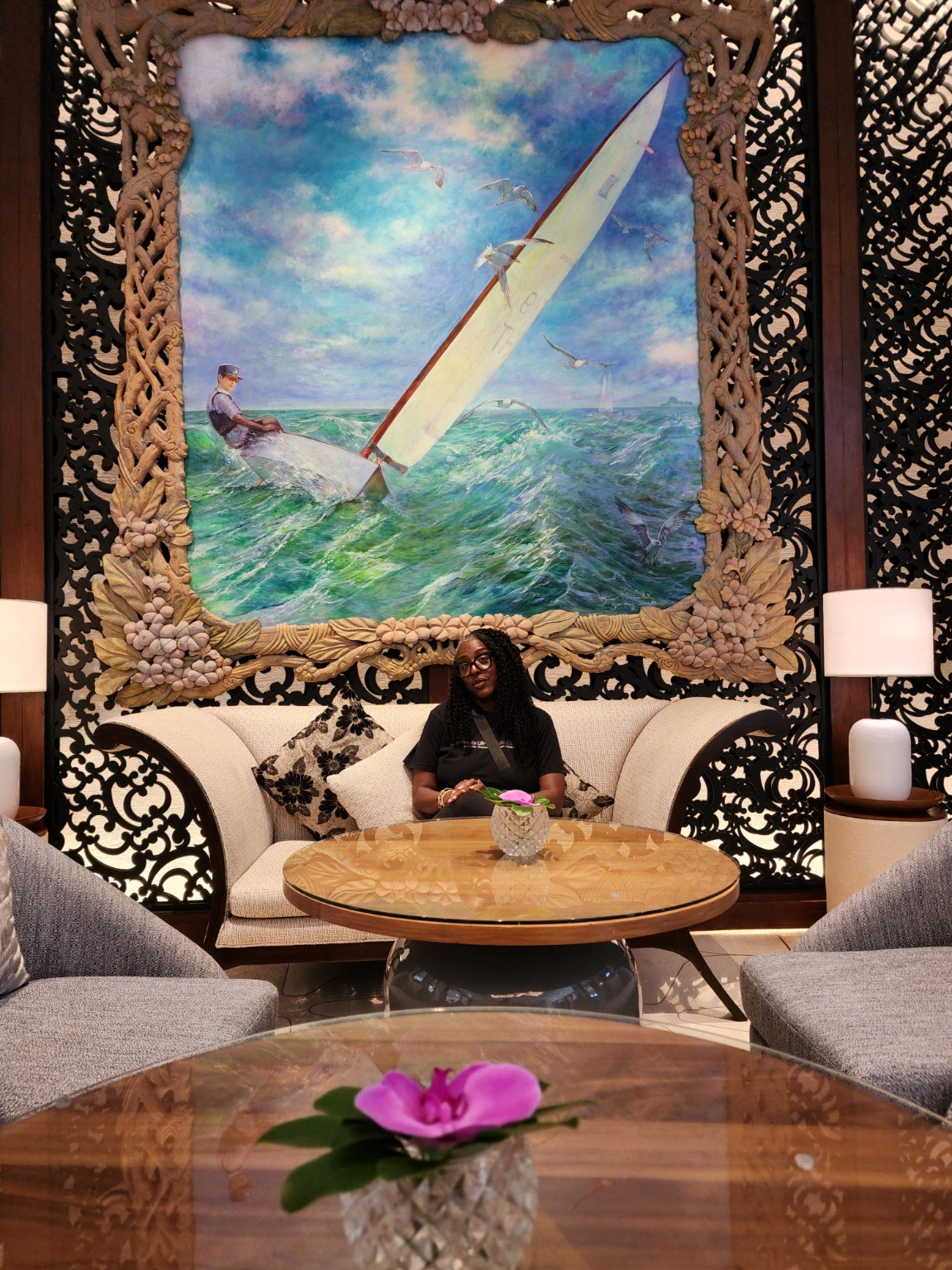 Tiffany seated beneath a large painting of a sailboat at sea