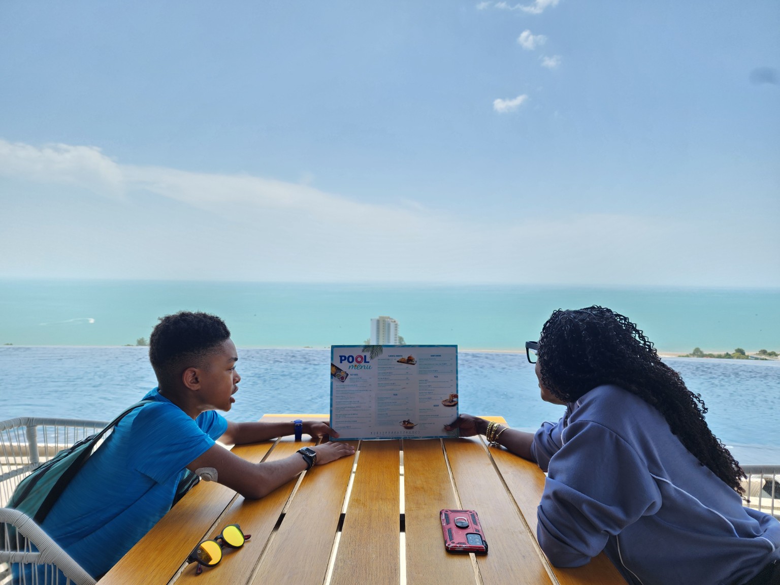 Tiffany and Myles sharing a poolside moment overlooking the sea