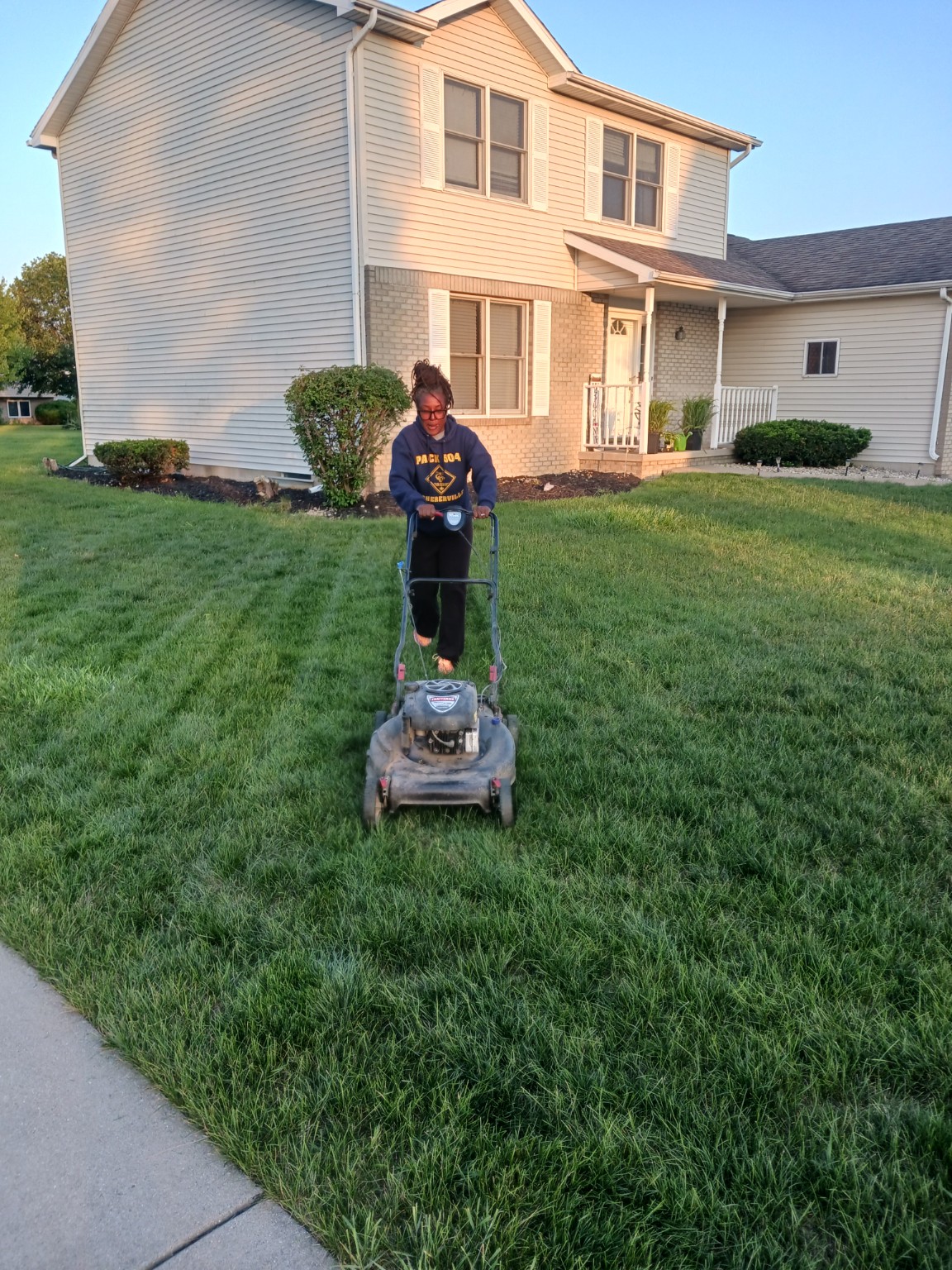 Tiffany mowing the lawn at home